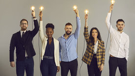 Junge Menschen halten Glühbirnen in die Höhe